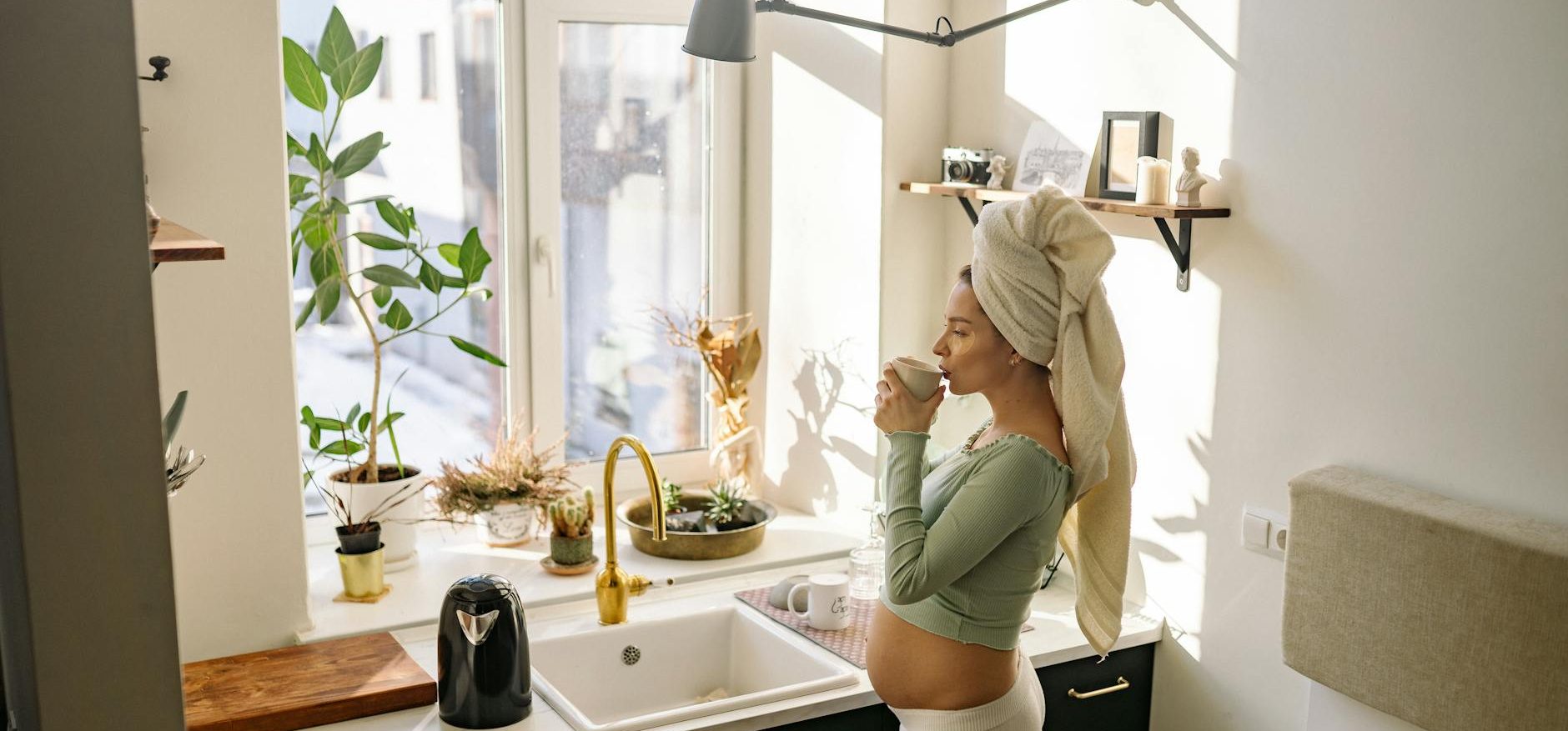 Femme enceinte buvant un thé dans une cuisine cocooning